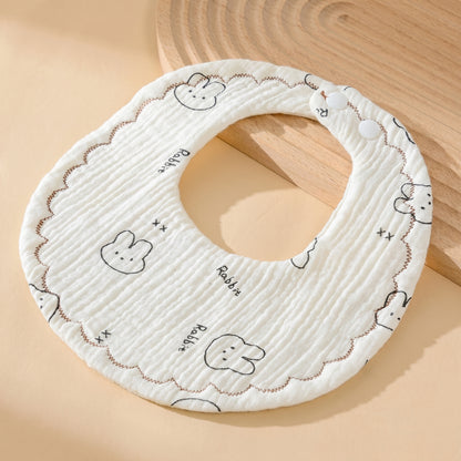WhisperSoft™ cotton bib in cream with rabbit prints and scalloped edges, designed for daily care.