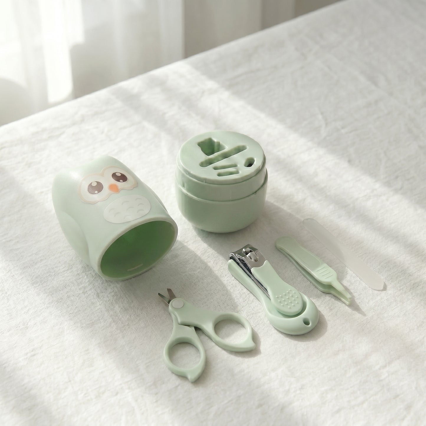 WhisperCare™ baby care kit in green, featuring an owl-shaped case, baby nail clippers, safety scissors, and a nail file.