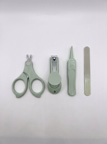WhisperCare™ baby care kit with green baby nail clippers, safety scissors, a nail file, and tweezers arranged neatly.