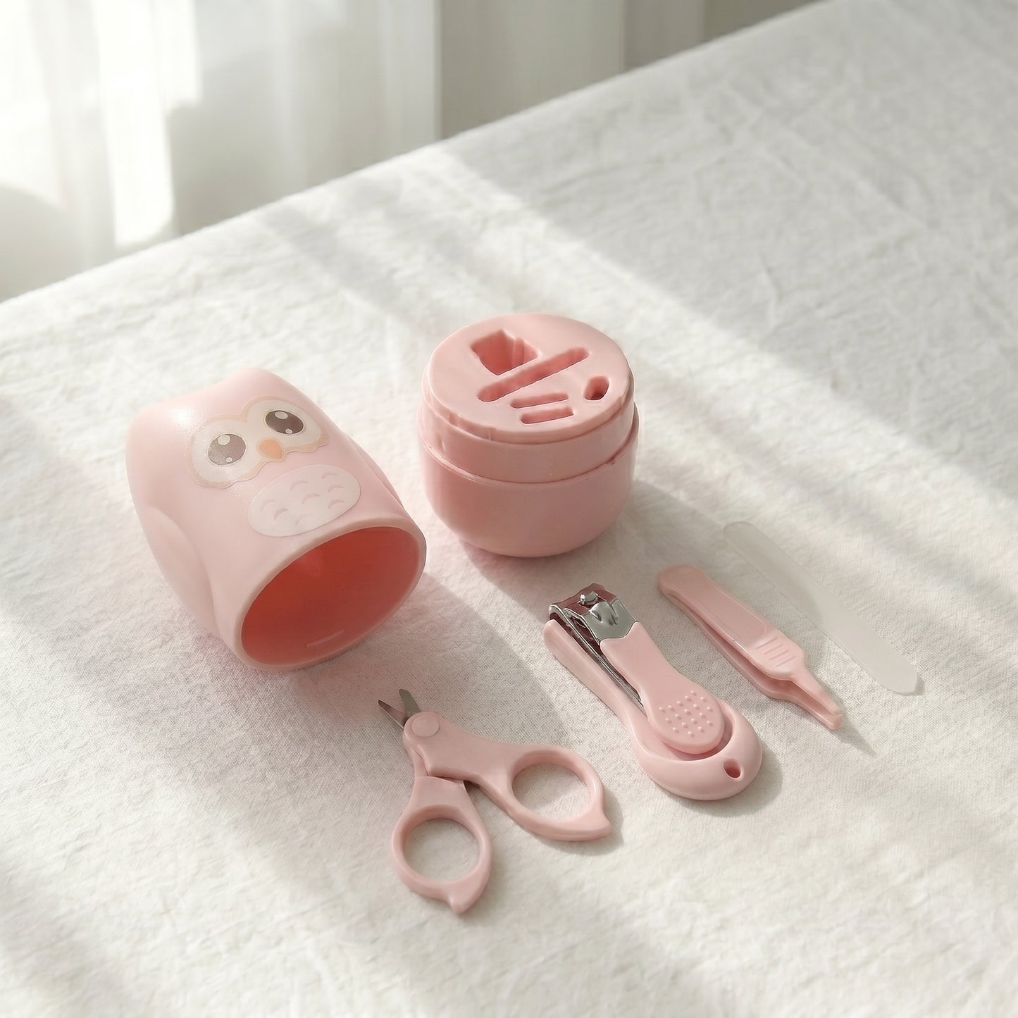 WhisperCare™ baby care kit in pink, featuring an owl-shaped case and baby grooming tools including safety scissors and nail clippers.