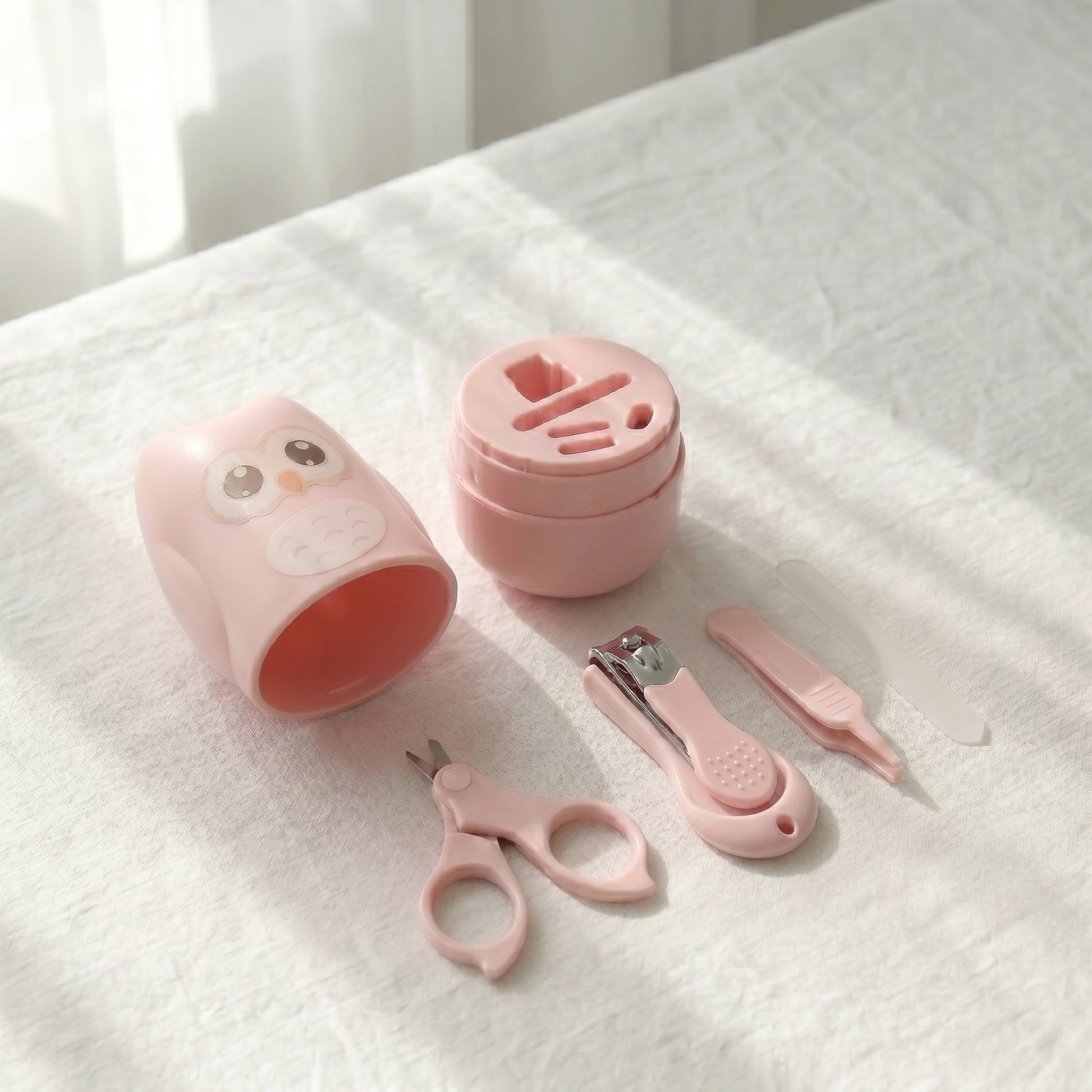 WhisperCare™ baby care kit in pink, featuring an owl-shaped case and baby grooming tools including safety scissors and nail clippers.