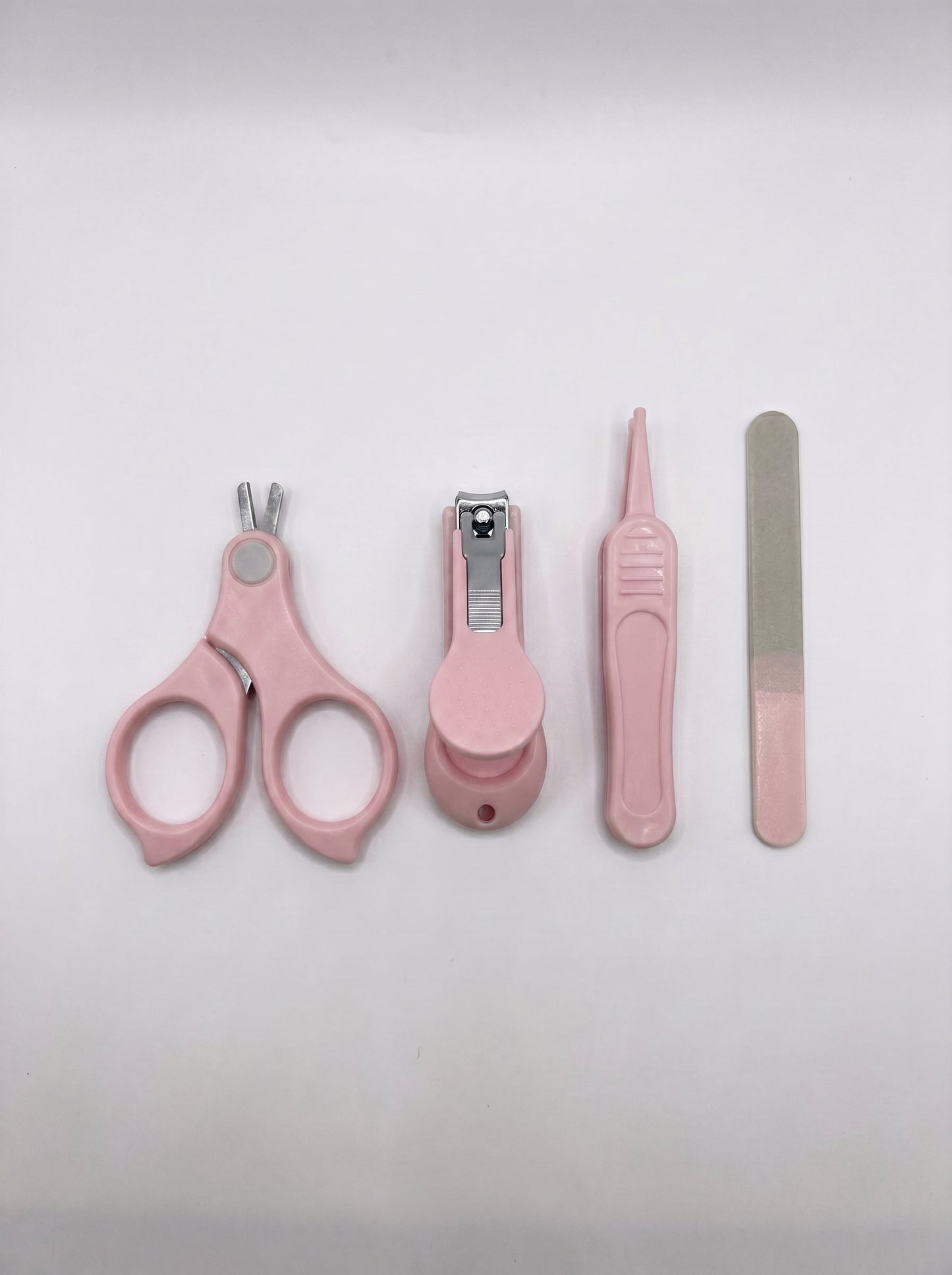 WhisperCare™ Baby Care Kit featuring pink baby nail clippers, safety scissors, a nail file, and tweezers arranged neatly.