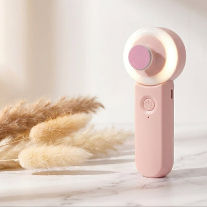Pink handheld device with a light on a marble surface with dried plants
